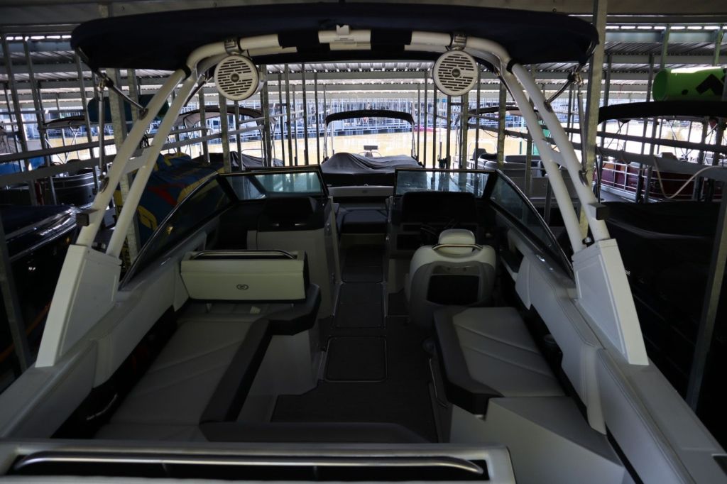 Interior view of a 2021 Cobalt R6 boat showing seating and controls, stored in a covered marina.