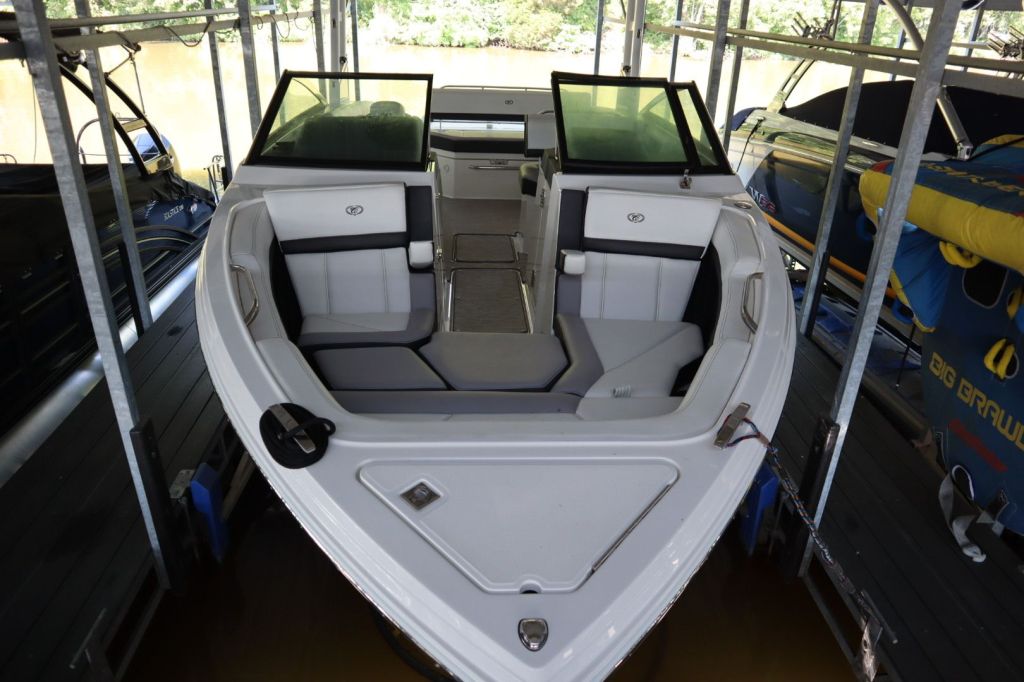 Interior view of a 2021 Cobalt R6 boat showcasing seating layout and storage, with surrounding boat lift and waterway.