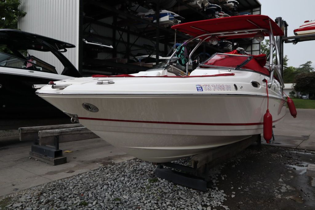 2007 Regal 2400 Bowrider boat on a trailer, showcasing its sleek design with a white hull and red accents.