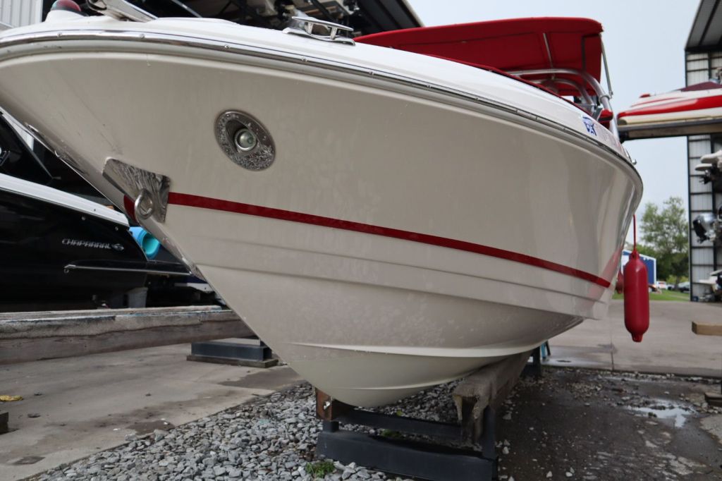 Close-up view of the bow of a 2007 Regal 2400 Bowrider boat, showcasing the Fast-Trac hull design with a red strip, mooring cleat, and a polished finish.
