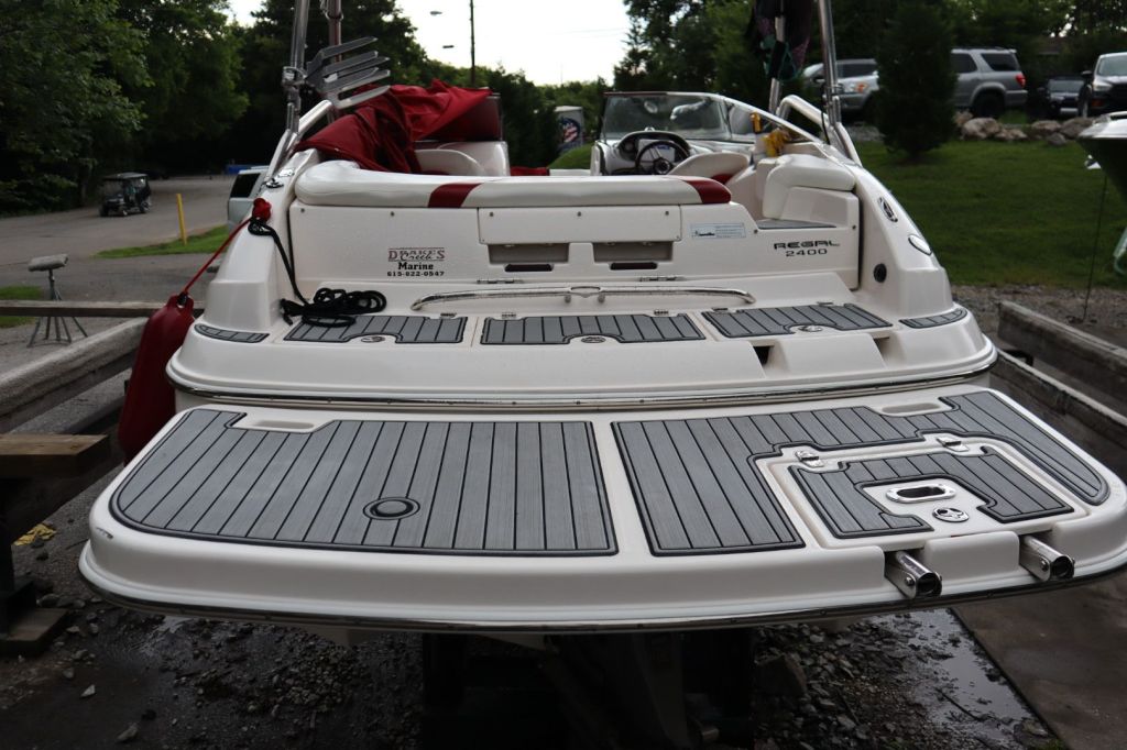 Rear view of a 2007 Regal 2400 Bowrider boat, showcasing new SeaDek flooring and dual prop outdrive.