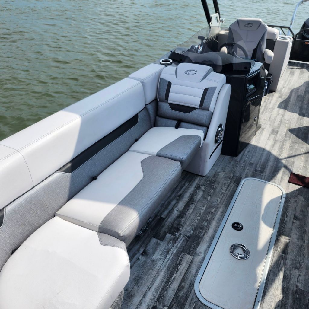 Interior view of the 2019 Crest 250 Caliber boat showing spacious seating area with light-colored upholstery and wood-like flooring.