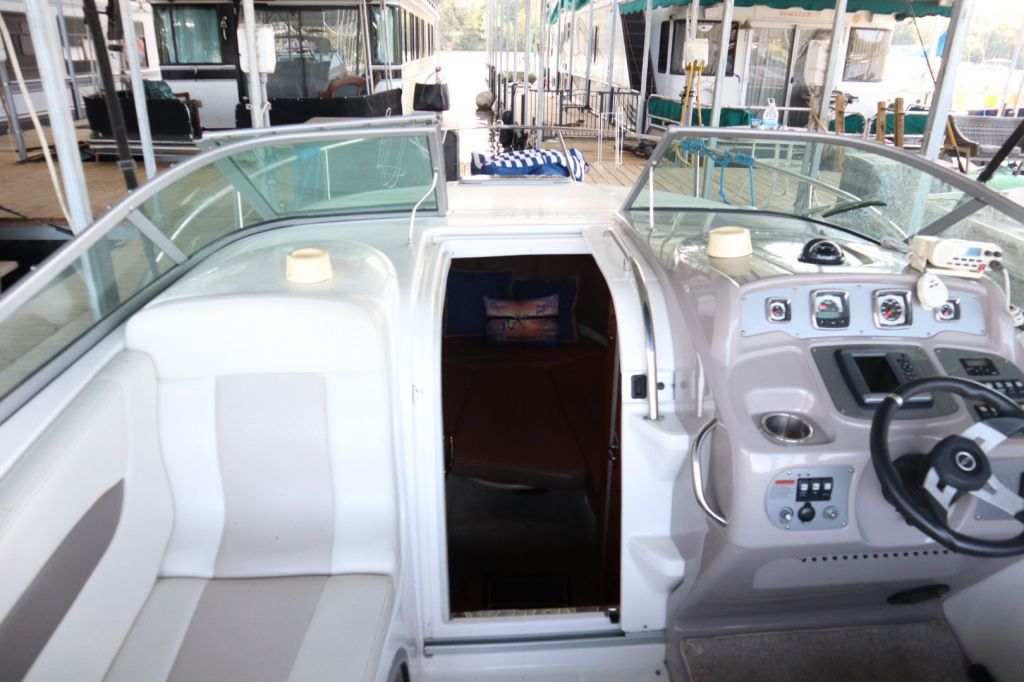 Interior view of a 2009 Chaparral 250 Signature boat showing the cockpit with steering wheel, dashboard controls, and access to the cabin.